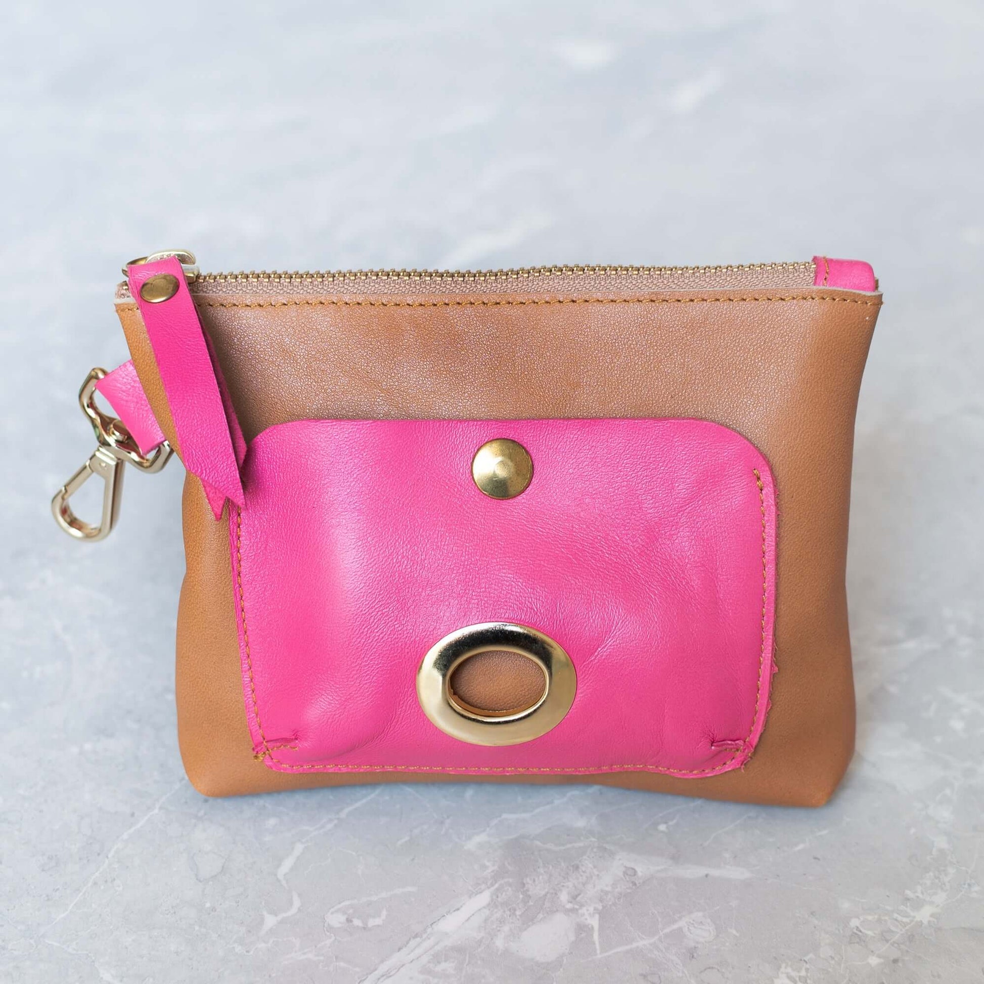 Piel de curtición vegana. Herrajes dorados de latón. Bolso de 18 x 14cmBolso piel color London con cierre de cremallera y bolsillo para bolsitas en dos colores, verde o rosa. Este bolso lleva mosquetón para colgar de la pulsera o de la correa.